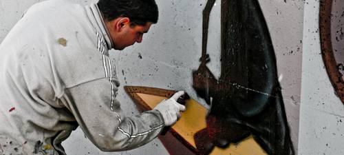 Technician removing moldy insulation in an attic