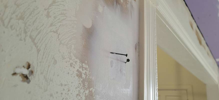 Visible mold on bathroom ceiling and tile, person cleaning with protective gloves