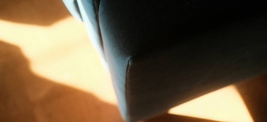 Visible mold on a fabric couch and wood chair being cleaned, close-up