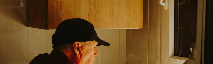 A worried homeowner reading mold FAQ and inspecting for signs of mold in their house