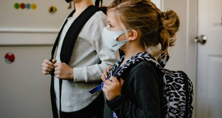 A family with visible mold in the home, one person sneezing and another consulting a doctor about health effects