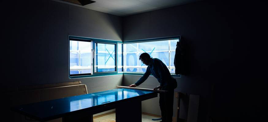 A homeowner reviewing insurance paperwork in a water-damaged living room