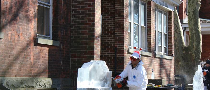 A person in PPE removing mold from a home wall, with visible mold patches and remediation tools