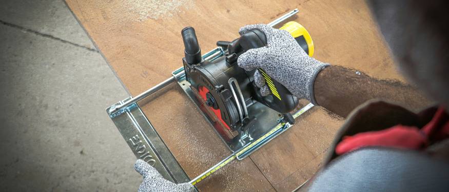 Technician inspecting for mold under hardwood or laminate flooring after water damage